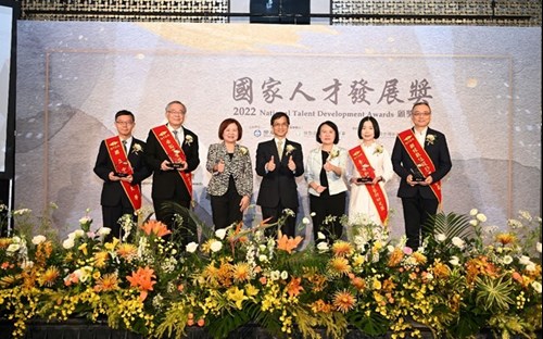 Minister Without Portfolio Lin Wan-I delivering an address, Minister Hsu Ming-Chun of the MOL, and Deputy Director-General Chung Chin-Chi posing for a group photo with representatives of awardee units.